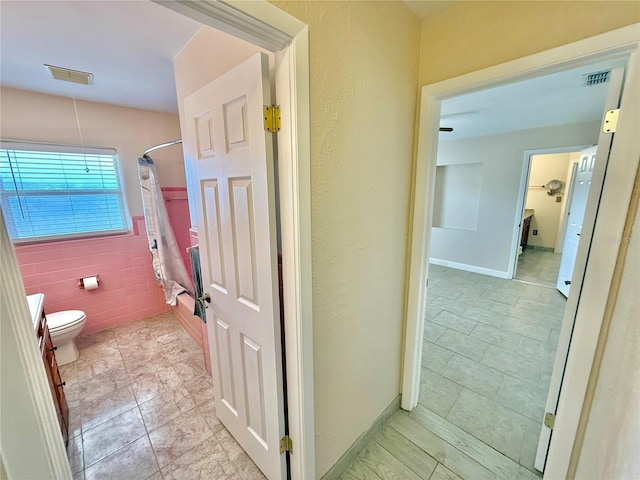 155 Avalon Ave, Flagler Beach, FL 32136 - bathroom featuring tile walls, tile patterned floors, and toilet