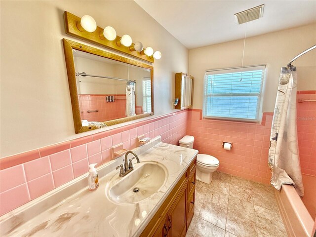 155 Avalon Ave, Flagler Beach, FL 32136 - full bathroom featuring vanity, shower / bath combo, tile walls, and toilet