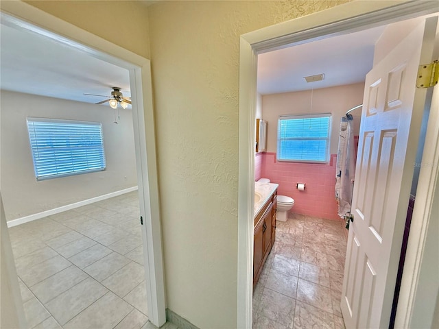 155 Avalon Ave, Flagler Beach, FL 32136 - bathroom with ceiling fan, tile patterned flooring, tile walls, vanity, and toilet