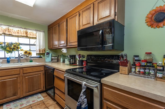 kitchen featuring light tile patterned floors, sink, and black appliances