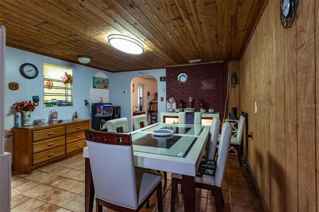 dining space featuring light tile patterned floors and wood ceiling