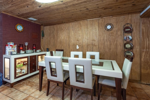 dining room featuring wood ceiling, tile patterned floors, and wood walls