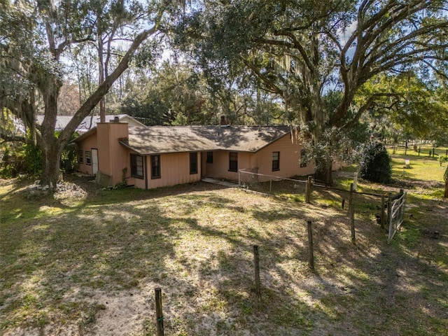 rear view of property featuring a lawn