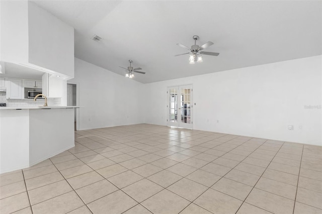 unfurnished living room featuring visible vents, ceiling fan, vaulted ceiling, french doors, and light tile patterned flooring