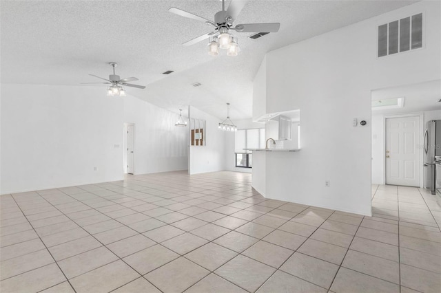 unfurnished living room with light tile patterned floors, visible vents, and ceiling fan