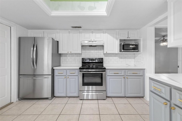 kitchen with visible vents, under cabinet range hood, tasteful backsplash, appliances with stainless steel finishes, and light countertops