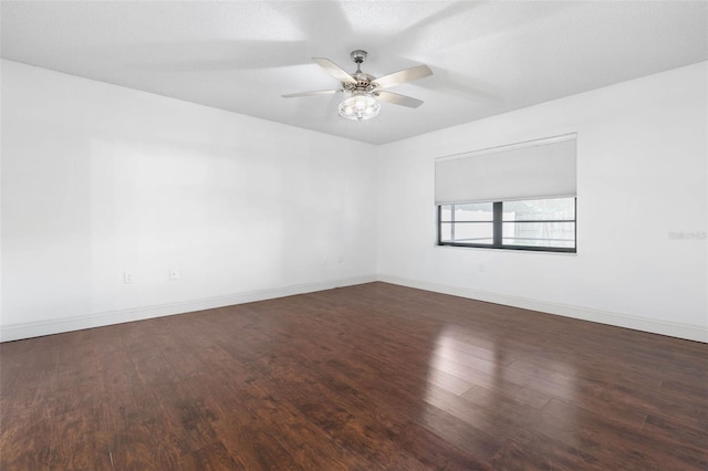 spare room featuring baseboards, a ceiling fan, and wood finished floors