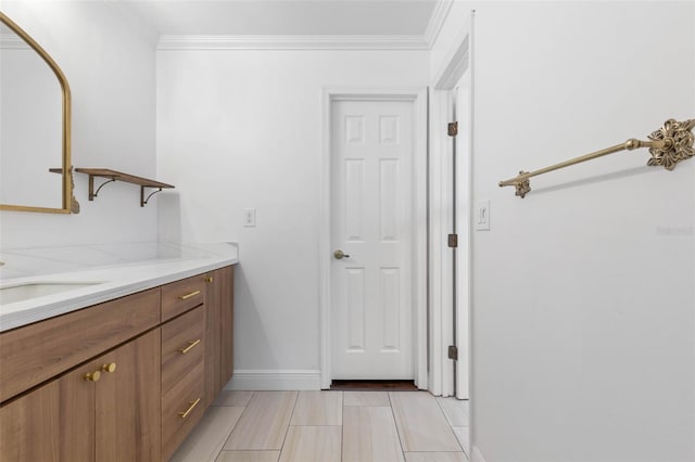 bathroom featuring vanity, crown molding, and baseboards
