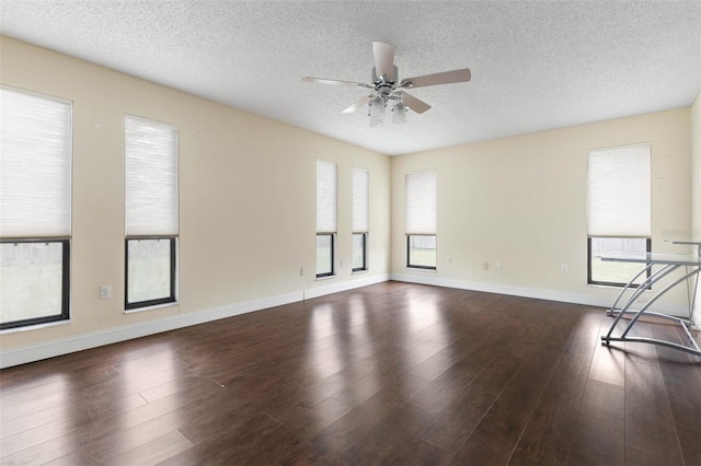 spare room featuring wood finished floors, plenty of natural light, and a ceiling fan