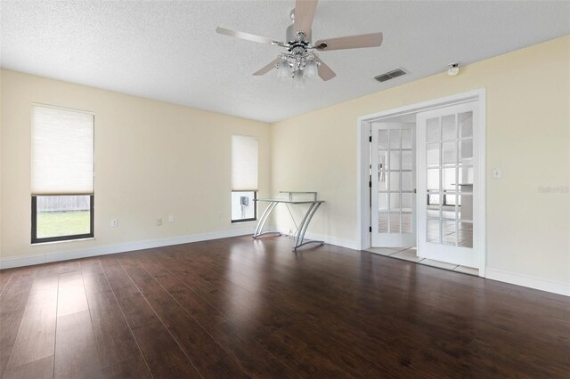 spare room featuring visible vents, baseboards, ceiling fan, wood finished floors, and a textured ceiling