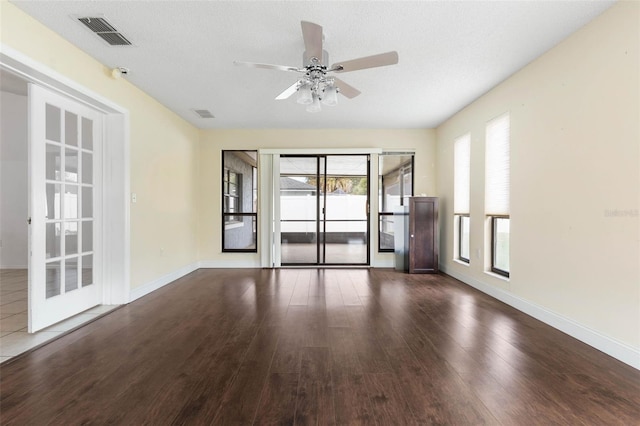 spare room featuring visible vents, baseboards, ceiling fan, and wood finished floors