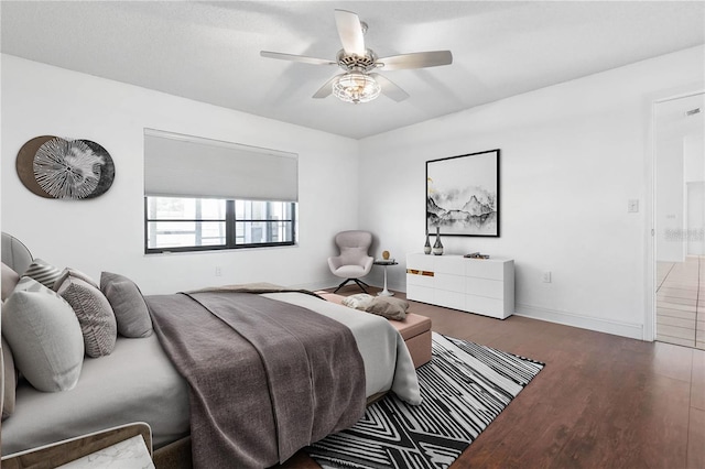 bedroom featuring ceiling fan, baseboards, and wood finished floors