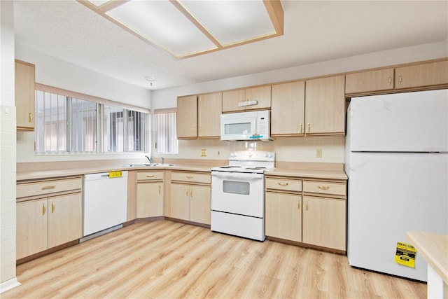 kitchen with light brown cabinetry, sink, backsplash, white appliances, and light hardwood / wood-style flooring