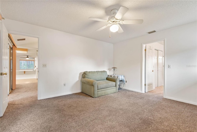 unfurnished room featuring ceiling fan, light carpet, and a textured ceiling