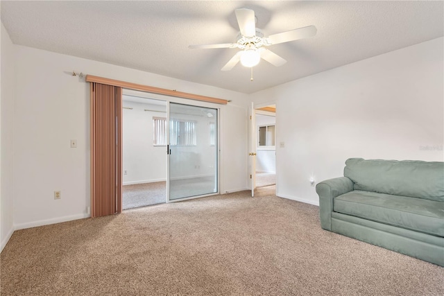 sitting room featuring ceiling fan, carpet floors, and a textured ceiling