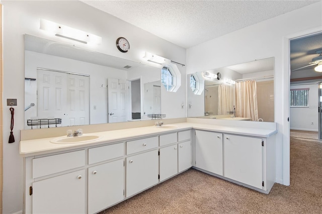 bathroom with vanity, ceiling fan, and a textured ceiling