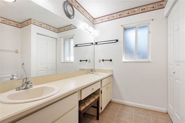 bathroom featuring vanity, tile patterned flooring, and a textured ceiling