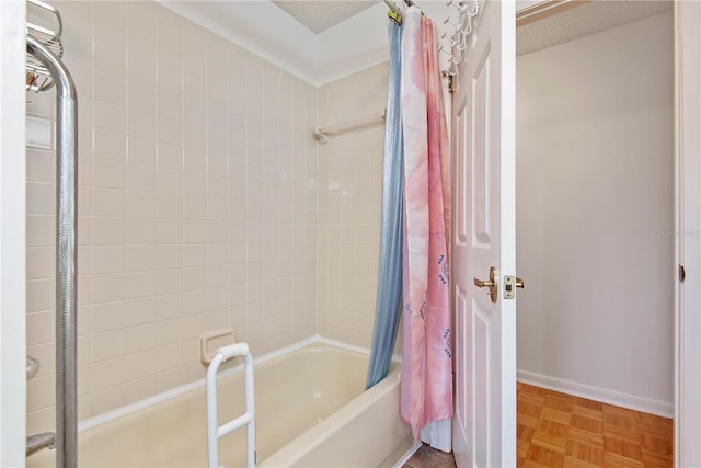 bathroom featuring parquet flooring, shower / bath combo with shower curtain, and a textured ceiling