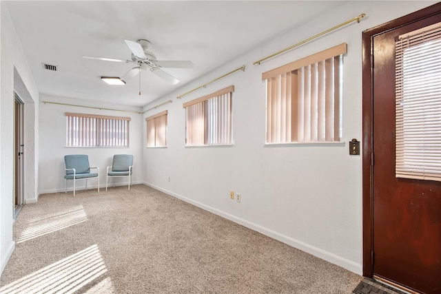 unfurnished office with ceiling fan and carpet