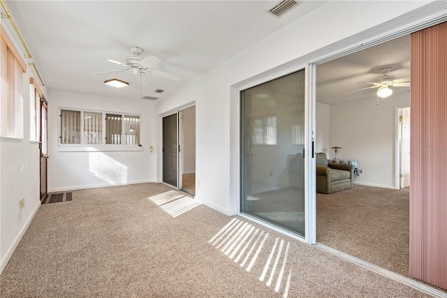 unfurnished sunroom with ceiling fan