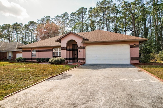 single story home with a garage and a front lawn