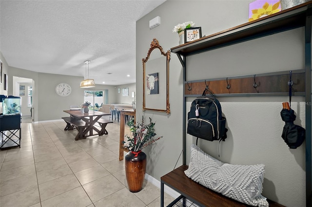 mudroom featuring a textured ceiling and light tile patterned floors