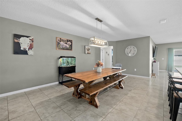 tiled dining space featuring a textured ceiling