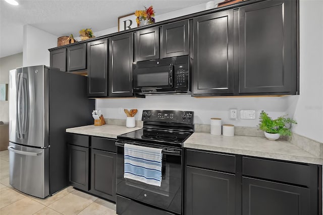 kitchen featuring light tile patterned floors, black appliances, and a textured ceiling