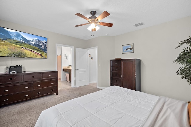 bedroom with connected bathroom, light colored carpet, and ceiling fan