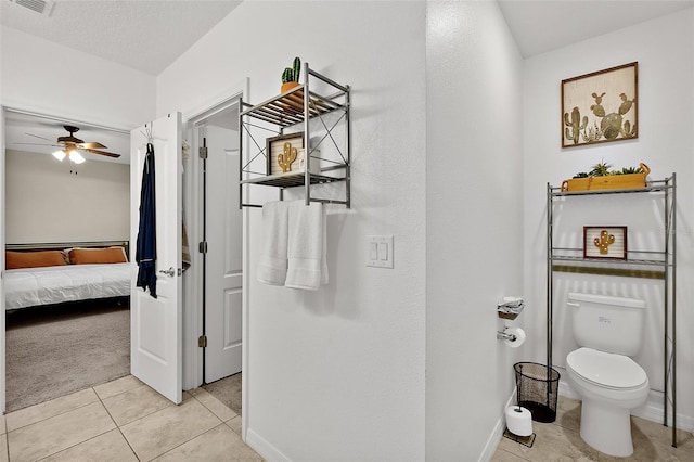 bathroom with ceiling fan, a textured ceiling, tile patterned floors, and toilet