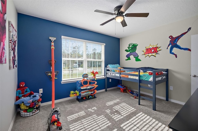 carpeted bedroom with ceiling fan and a textured ceiling