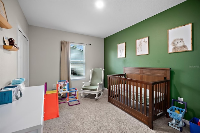 bedroom with a crib and carpet