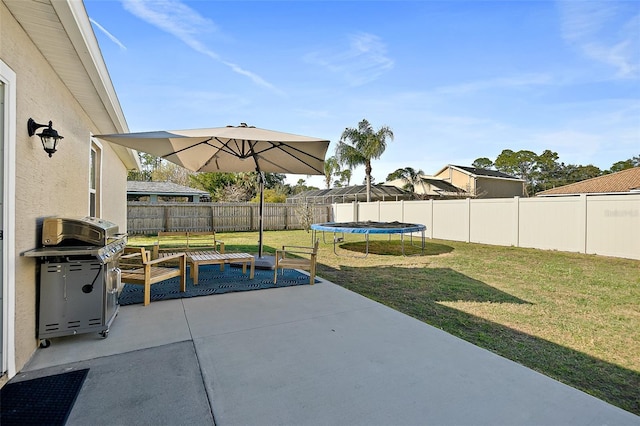 view of patio with area for grilling and a trampoline