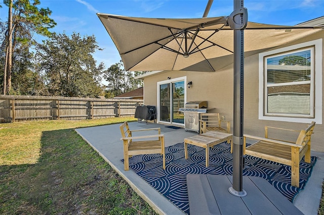 wooden deck featuring a grill, a lawn, and a patio