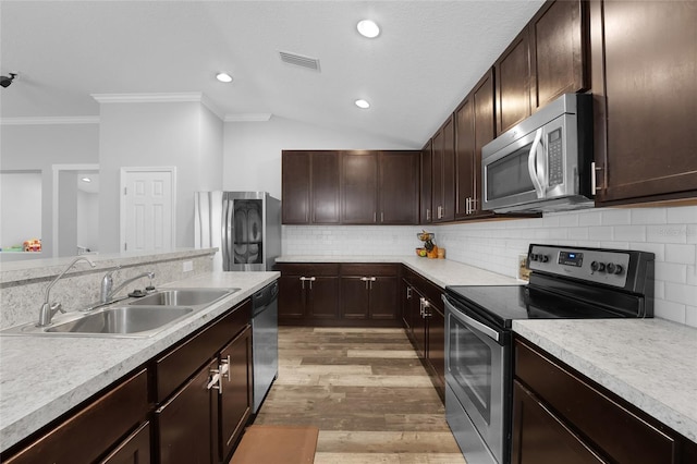 kitchen with dark brown cabinetry, sink, tasteful backsplash, stainless steel appliances, and light hardwood / wood-style floors