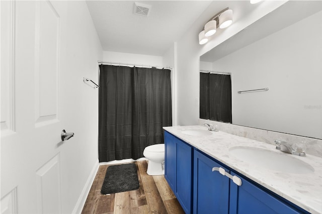 bathroom featuring walk in shower, vanity, toilet, and hardwood / wood-style floors