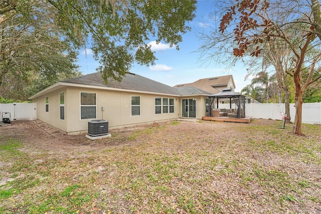 rear view of property with a gazebo, central AC, and a lawn