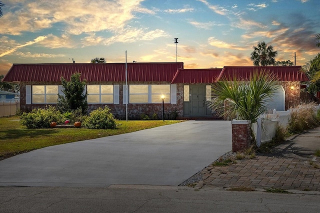 view of front of property featuring fence and concrete driveway