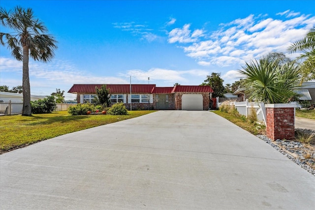 view of front of home with an attached garage, concrete driveway, a front yard, and fence