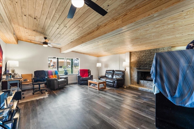 living area with vaulted ceiling with beams, wooden ceiling, a large fireplace, wood finished floors, and a ceiling fan