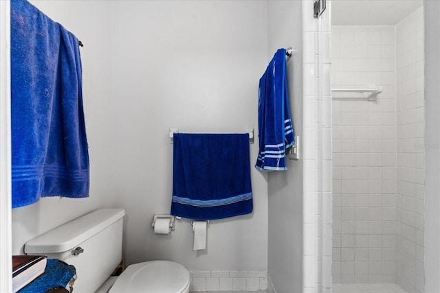 full bathroom with tiled shower and toilet