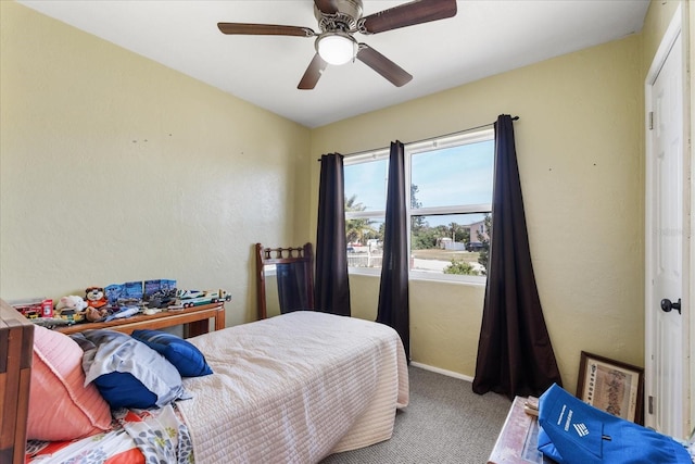 carpeted bedroom with ceiling fan and baseboards