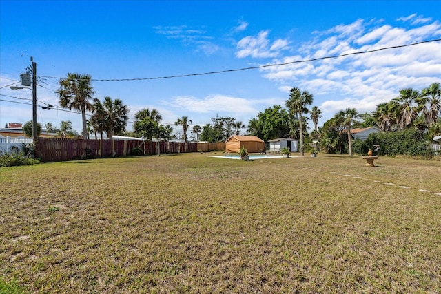 view of yard with a shed, fence, and an outdoor structure