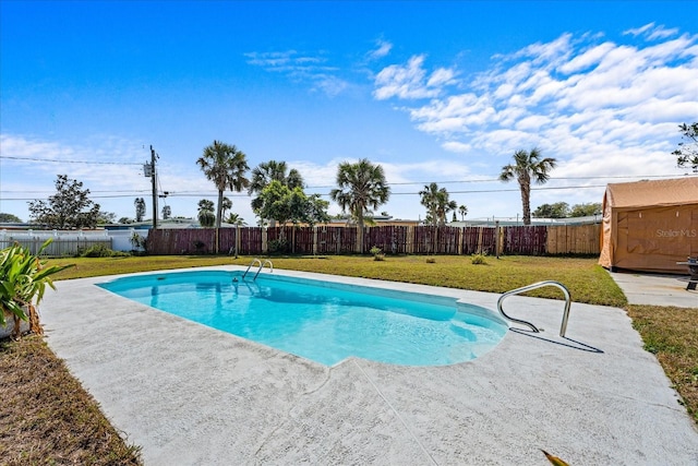 view of pool featuring a fenced backyard, a storage shed, an outdoor structure, a lawn, and a patio area