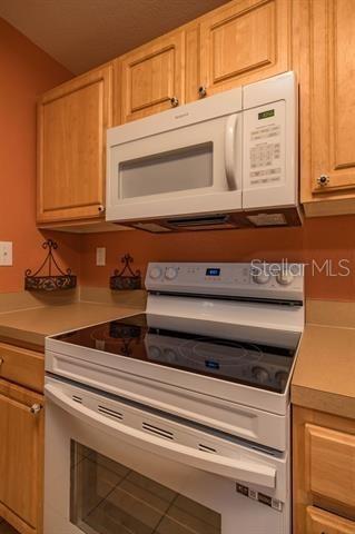 kitchen with light brown cabinets and white appliances