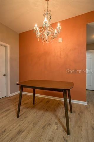 unfurnished dining area with hardwood / wood-style floors and a chandelier