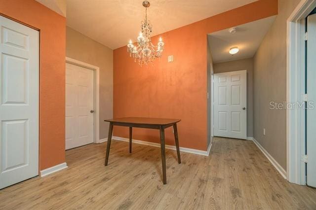 dining area featuring a notable chandelier and light wood-type flooring