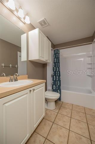 full bathroom with tile patterned floors, toilet, vanity, and shower / bath combo