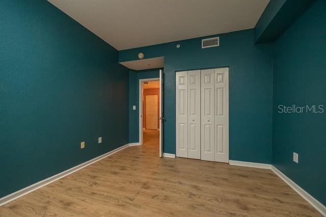 unfurnished bedroom featuring hardwood / wood-style floors and a closet