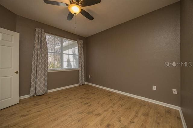 spare room featuring hardwood / wood-style flooring and ceiling fan